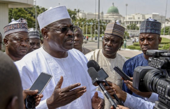 AI-generated editorial illustration of Senator Ali Ndume addressing reporters outside the National Assembly